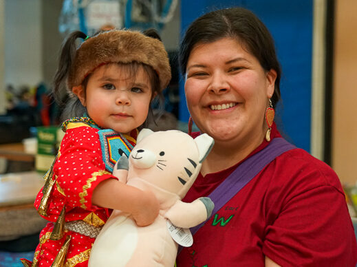 A mother and her daughter smile during the Powwow