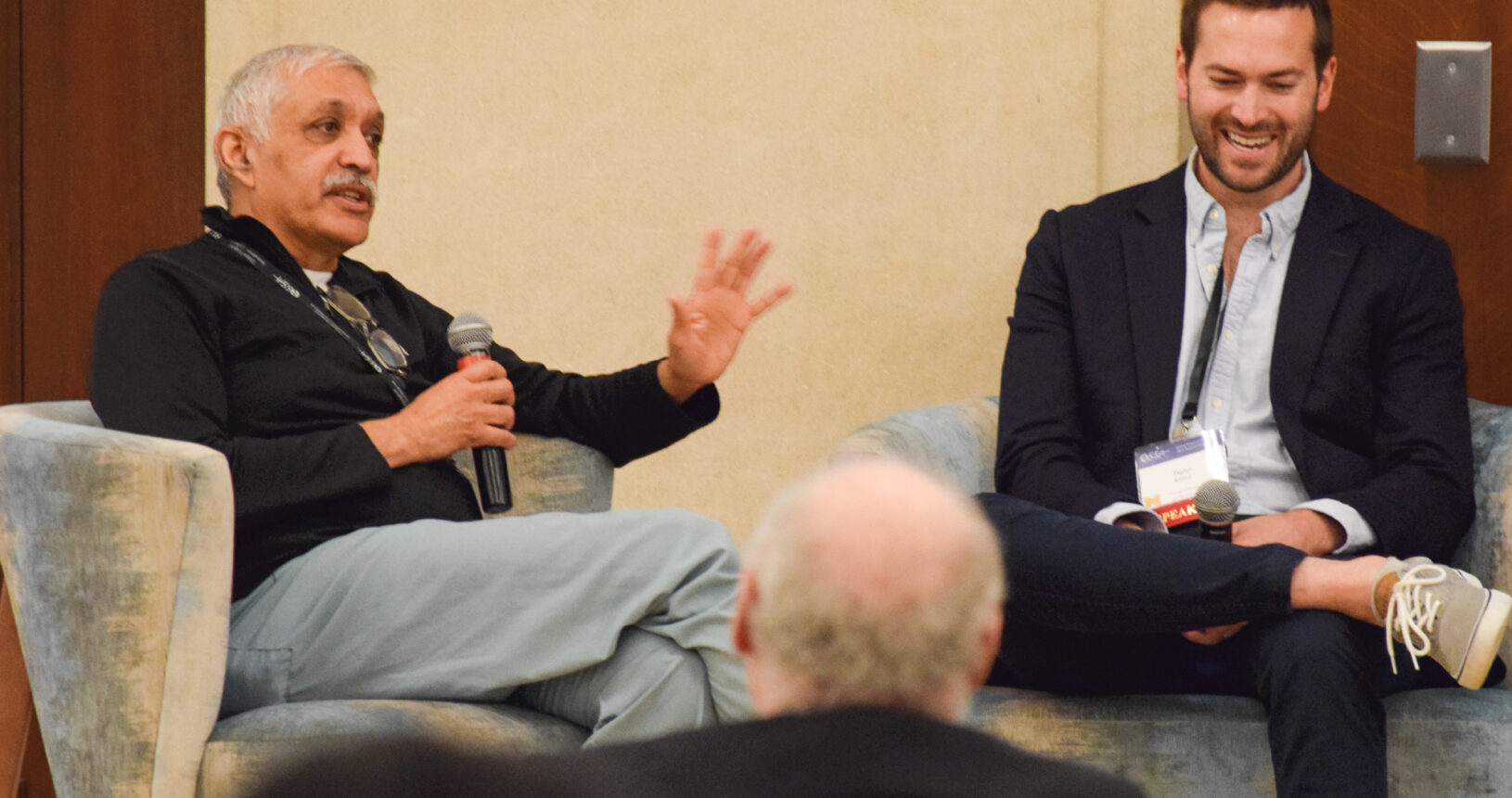 Photo of speaker onstage talking to an interviewer