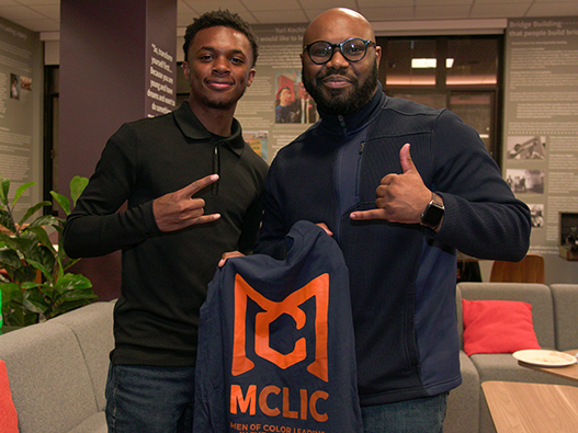 Photo of Greg and a student holding up an M-CLIC tshirt