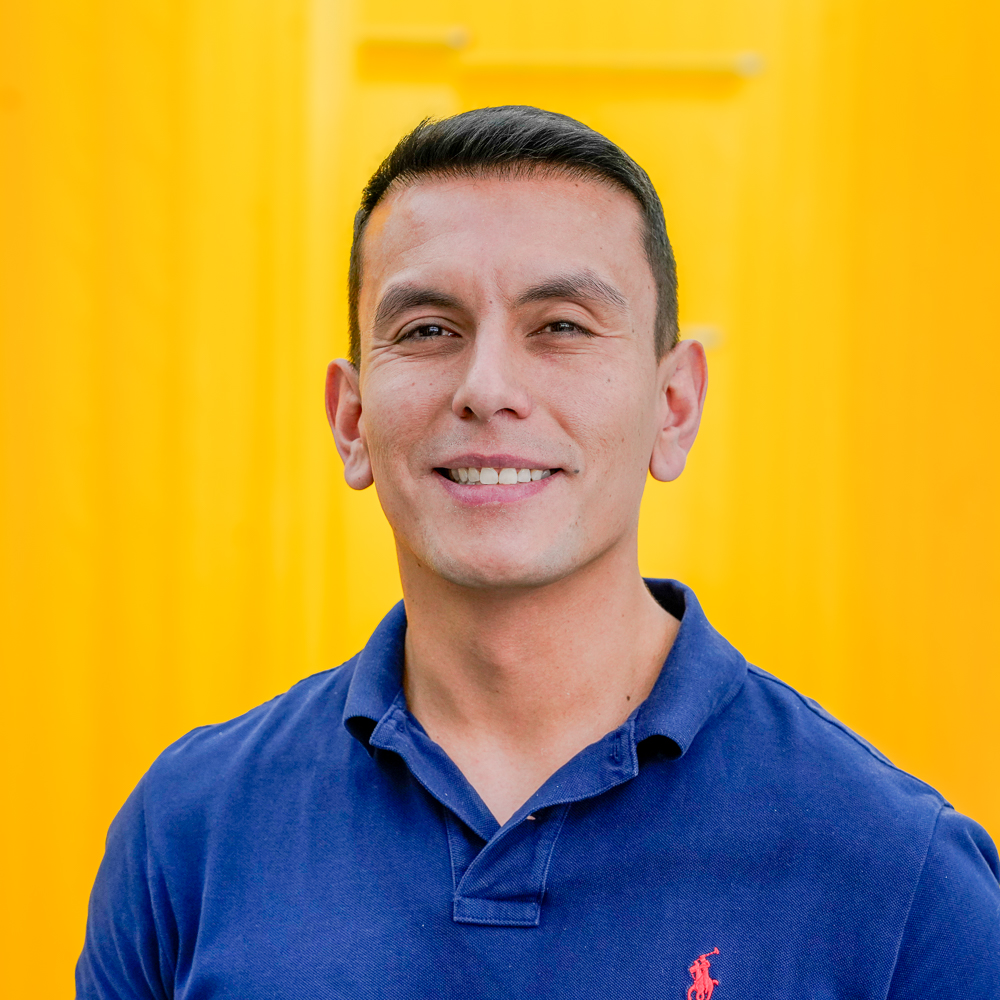 Photo of Hector with a blue polos shirt on yellow background