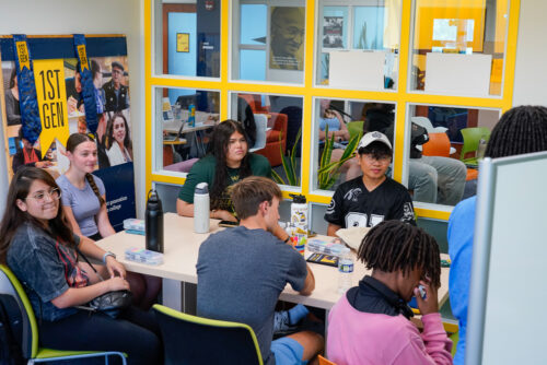 A group of students look at a white board and discuss how to thrive in college
